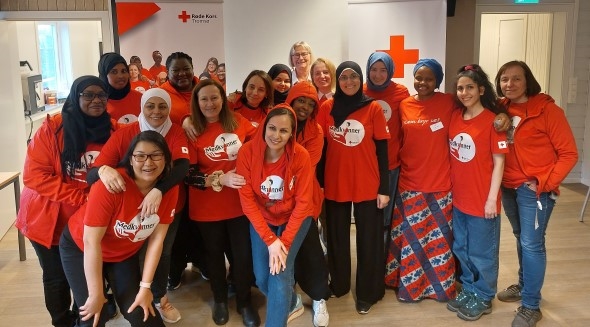 Bildet viser flere kvinner som står sammen og smiler.