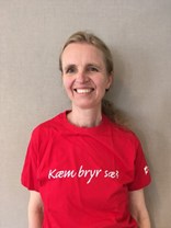 Nina Moe-Nilssen ser mot kameraet og smiler. Hun har på seg en rød tskjorte med påskriften "Kæm bryr sæ?". 