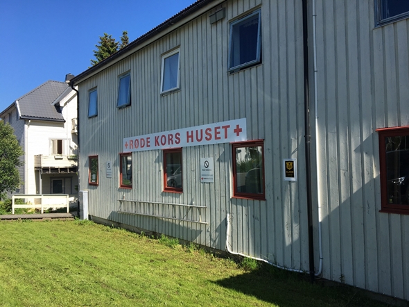 Bildet viser Røde Kors-huset i Tromsø i delvis sol. Det er sommer og grønn plen foran huset.