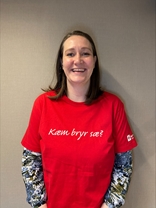 Silje Folkvord ser mot kameraet og smiler, i en rød tskjorte med påskriften "Kæm bryr sæ?". 