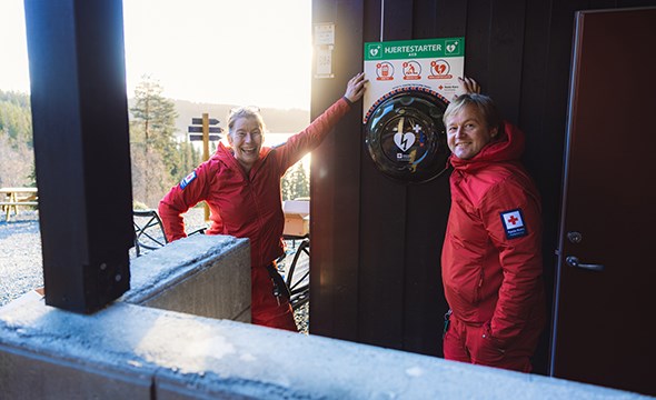 Frivillige poserer smilende ved nylig montert hjertestarter ved Grønlia i Bymarka.