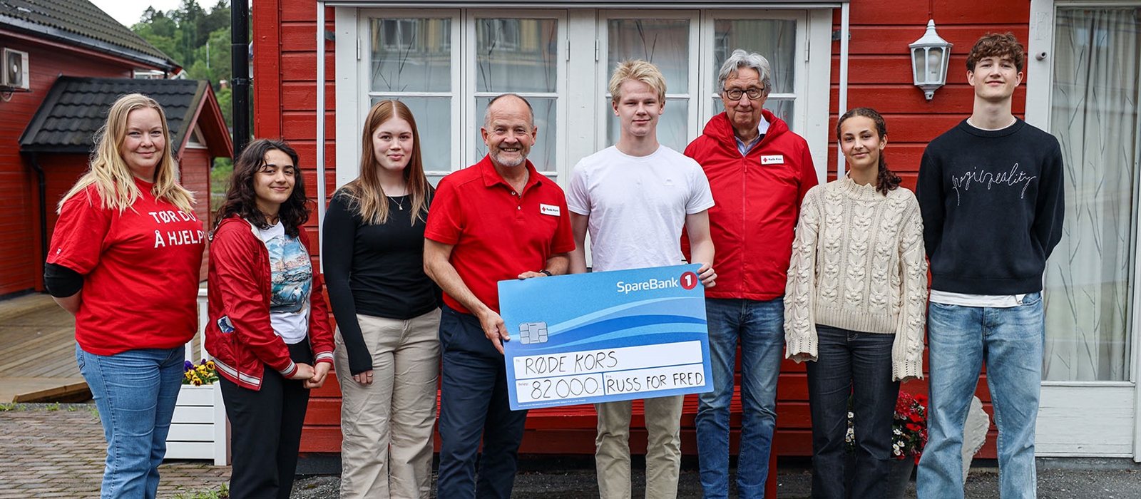 Gruppebilde av ungdom fra Levanger som gir en sjekk til Røde Kors i Trøndelag
