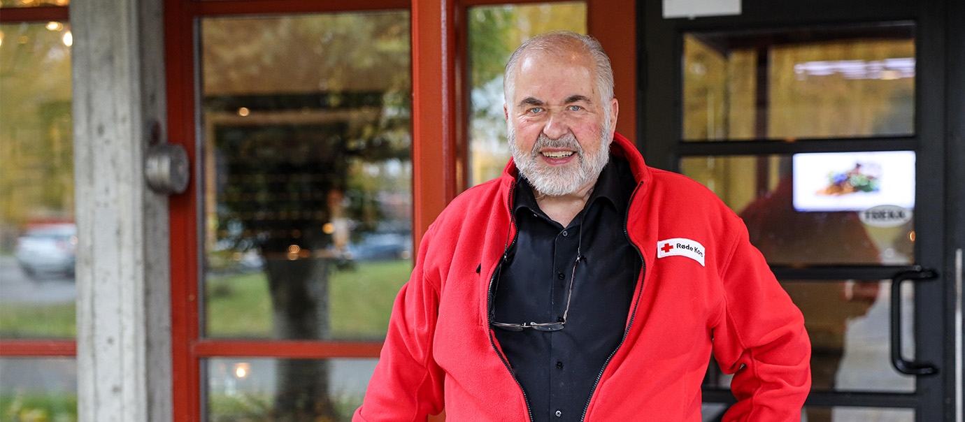Gunnar Lysholm står foran dørene på Bårdshaug Herregård med rødfarget Røde Kors-jakke på