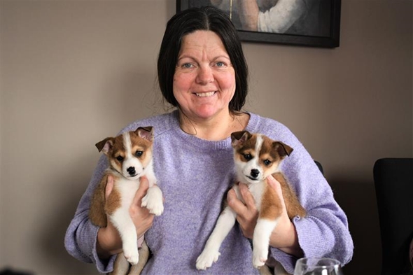 Bilde av Merethe Boneng som holder to hundevalper