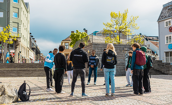 Utendørs på parkbenk. Frivillige i samtale med ungdommer.