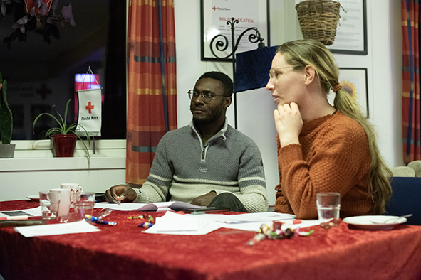 En dame og en mann sitter ved et bord i dyp samtale