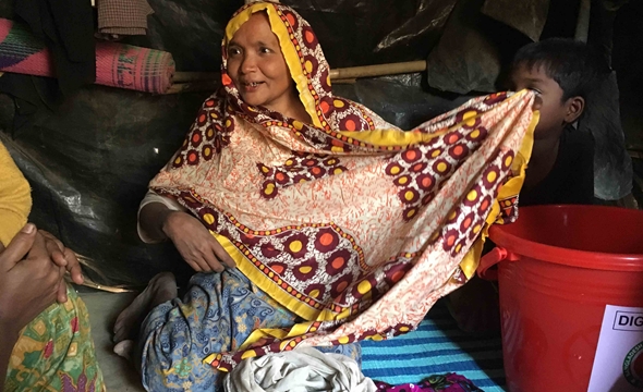 Burampara camp in Cox Bazar. Nur Begum (45) received a Dignity Kit from the IFRC and Bangladesh Red Crescent. The kits include culture and gender specific items, such as a long dress, scarves, underwear, sandals, and menstruation cloth (Photo: Lynette Nyman, IFRC).