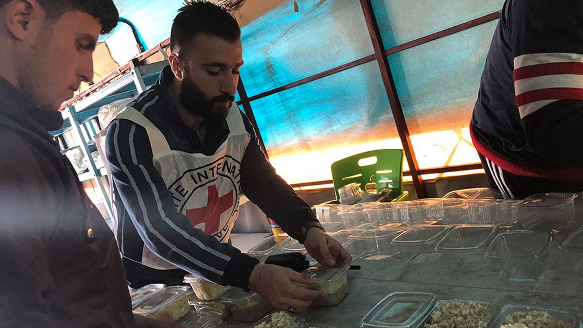 Men arranging food parcels inside truck, syria al hol