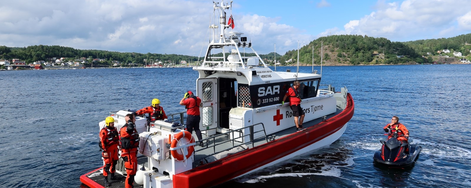 Mann og dame i uniform på redningsbåt.