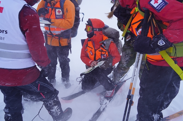 En gruppe mennesker står samlet og leser kart.