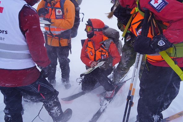 En gruppe mennesker står samlet og leser kart.