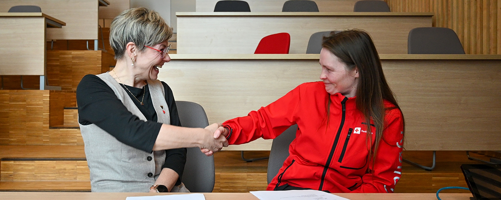 To damer som tar hverandre i hånden