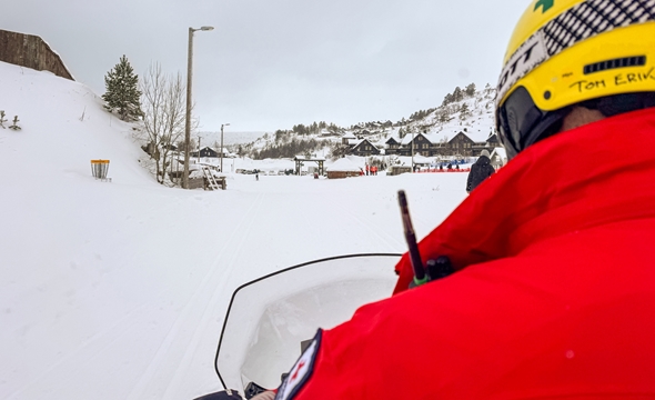 hjelm og snøscooter, sett fra passasjersetet