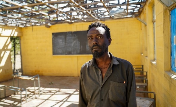 En frivillig lærer står ved en midlertidig uformell barneskole nord i Tigray.