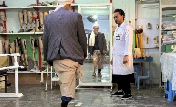 En mann får hjelp til justering av en benprotese ved et rehabiliteringssenter.