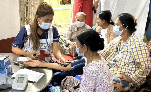 en kvinnelig sykepleier snakker med en gruppe kvinner på en helseklinikk.