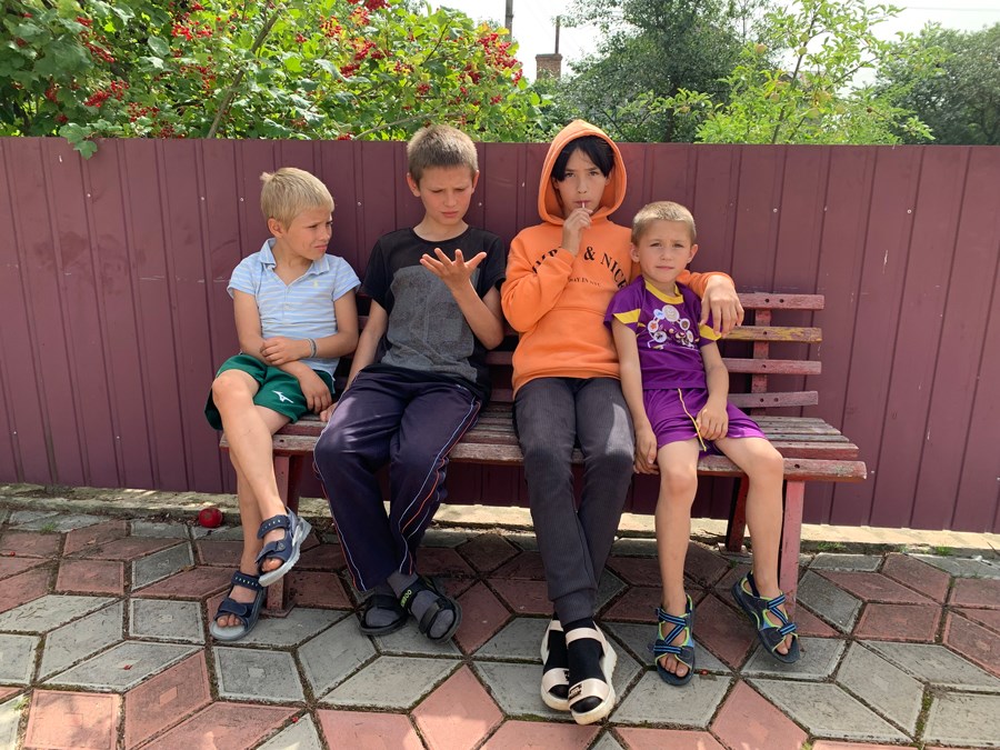 Fire barn sitter på benk