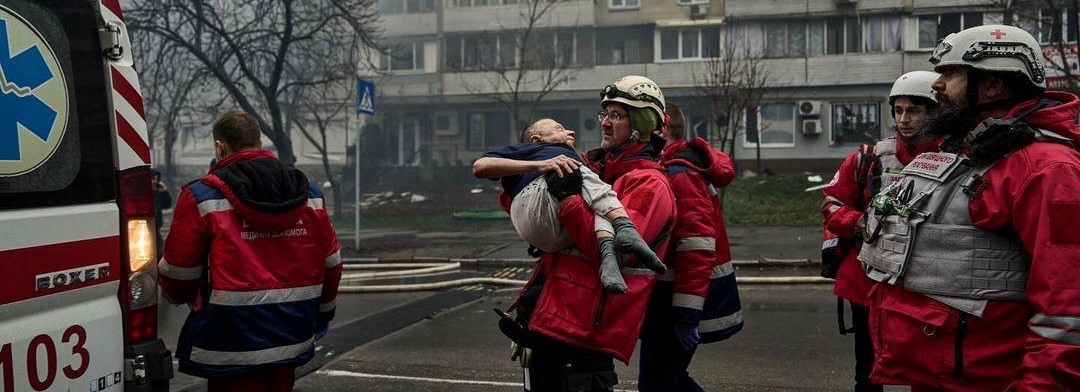 En person blir båret av frivillige inn i en ambulanse