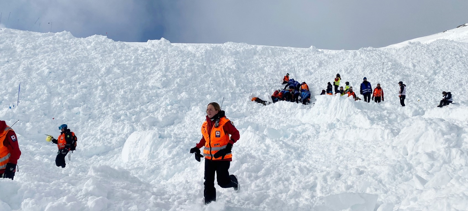 Frivillige fra Røde Kors gjennomfører en skredøvelse ute i snøen.