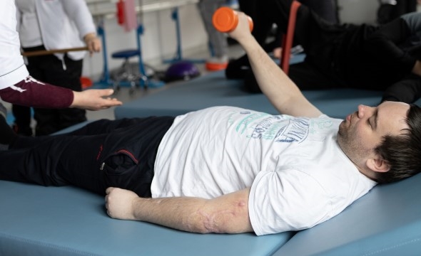 En mann som er skadet i krigen trener på et rehab-senter og får hjelp fra Røde Kors.