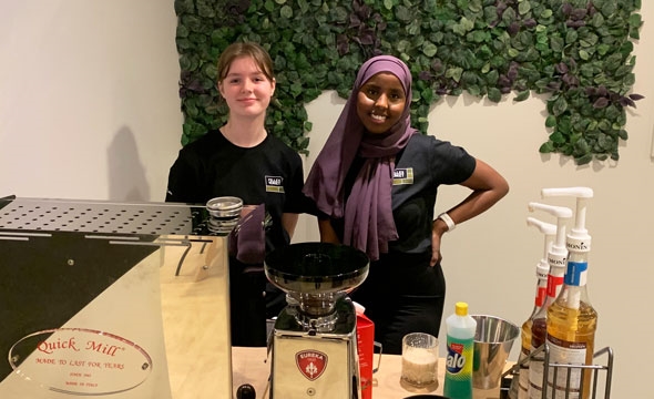 To jenter ved kaffemaskin