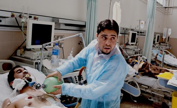 En lege står over en pasient som er hardt skadet på et sykehus i Libya.