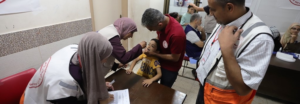 En liten gutt får poliovasine gjennom to dråper i munnen.