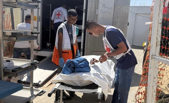 en person registrerer en død person som ligger på en båre.