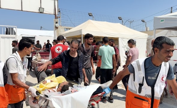 En såret pasient blir trillet på en båre inn på feltsykehuset til Røde Kors på Gazastripen.