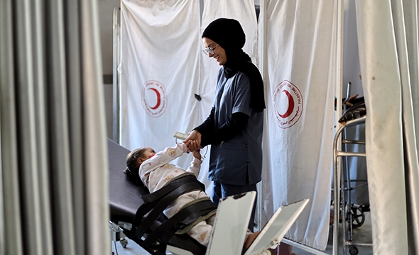 Mirna på tre år trener seg opp igjen til å gå og får hjelp av en sykepleier.