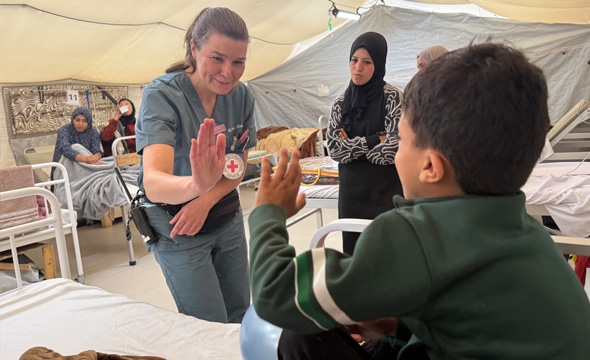 Lege gir en barnepasient high five i feltsykehuset på Gaza