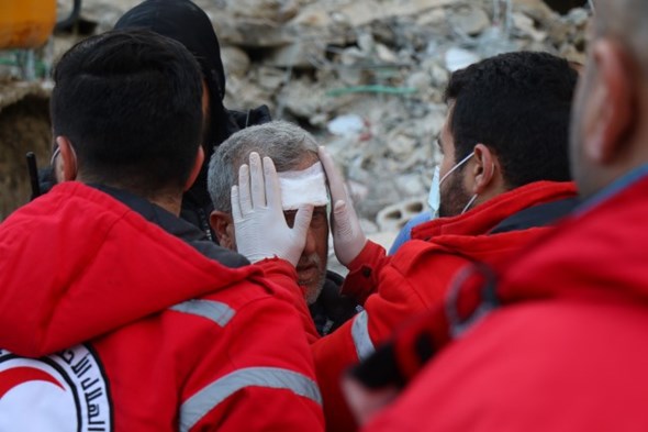 En mann får sårstell av Syrisk Røde Halvmåne etter jordskjelvet