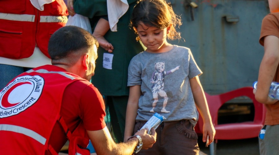 Frivillig deler ut mat og vann