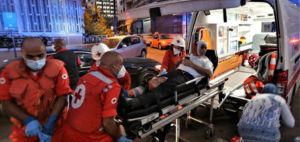 Ambulansepersonell fra libanon Røde Kors haster skadet person inn i ambulansen