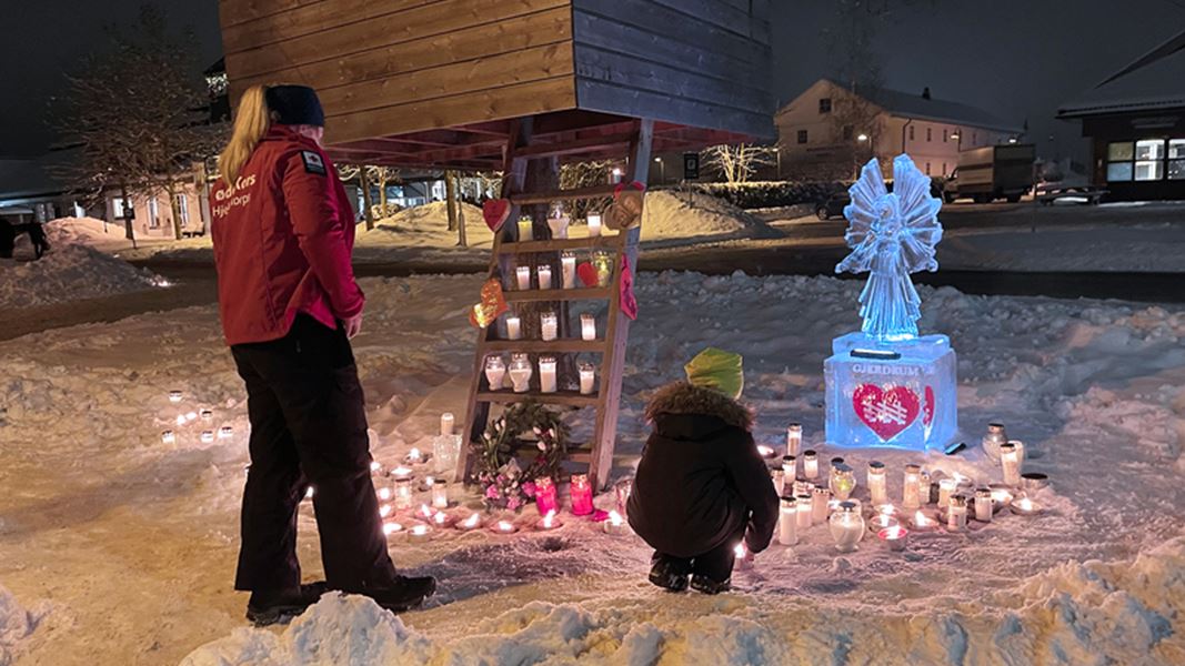 En kvinne og et barn ser på minneplass for de omkomne i Gjerdrum