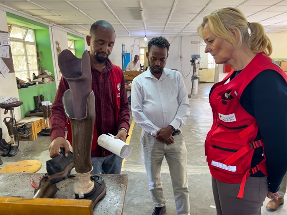 En mann lager en fotprotese. Anne Bergh følger med.