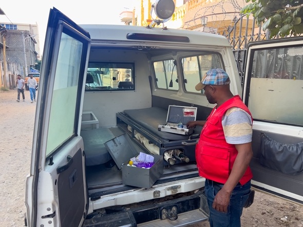 En ambulansesjåfør viser innholdet i at medisinskrin som nesten er tomt. Han står i en ambulanse uten noe utstyr.