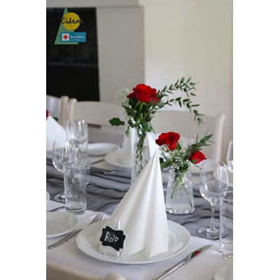 Pyntet festbord med hviteservietter og røde roser