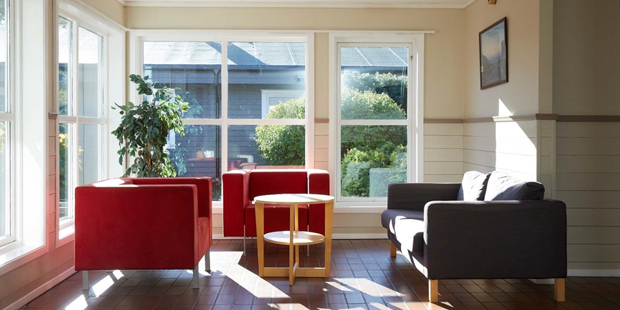 Interiør sittegruppe i rødt med store binduer