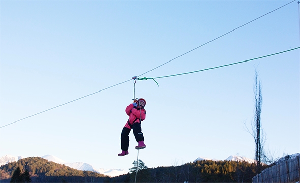 Mathine Øye svever uredd over tunet hengende i ziplinen