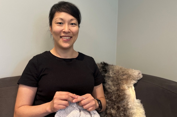 Dame sitter i sofa og strikker