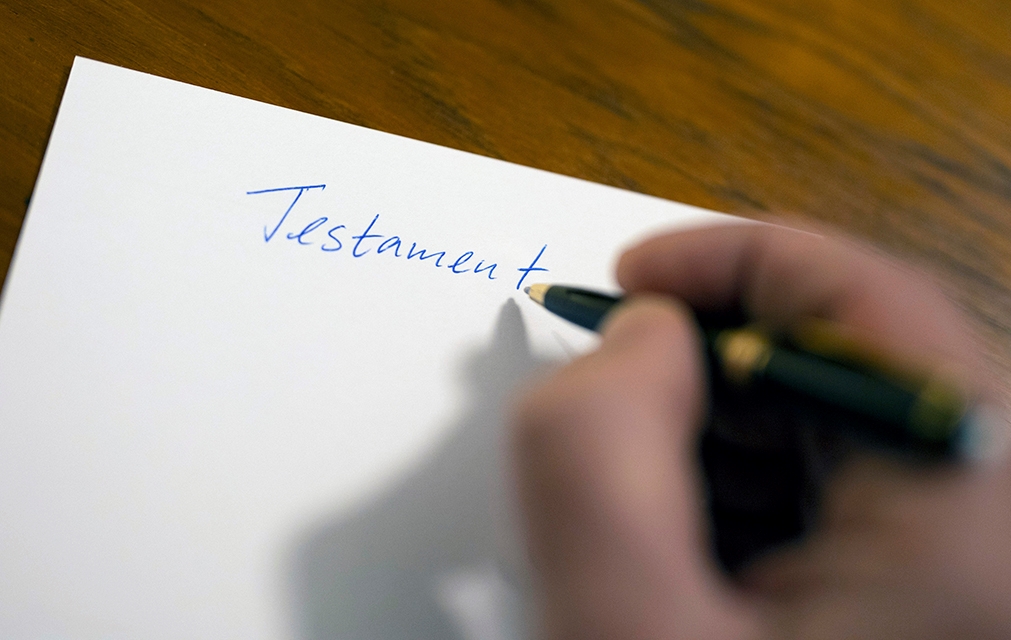 En hånd som skriver ordet testament