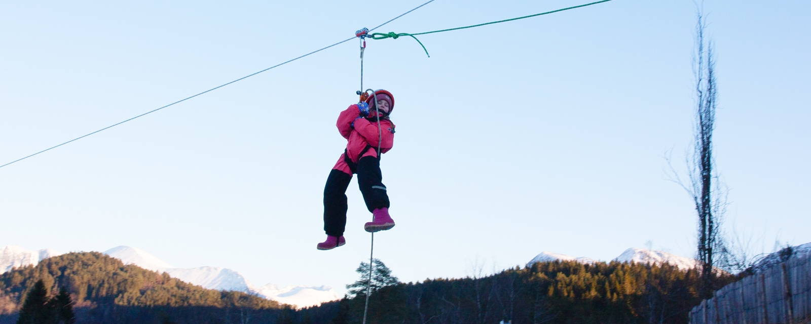 Jente henger i zipline på vinterstid.