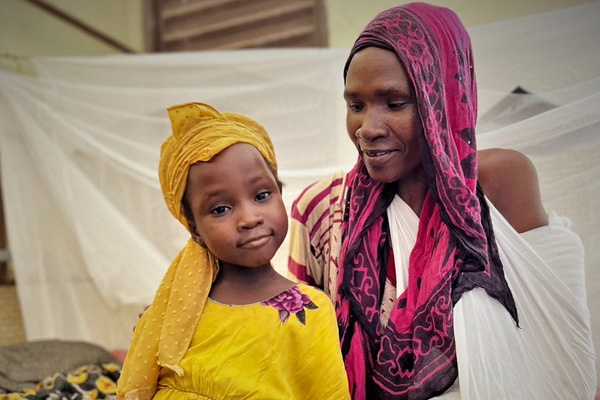 Mor og datter blir tatt vare på etter at de har flyktet i Sudan