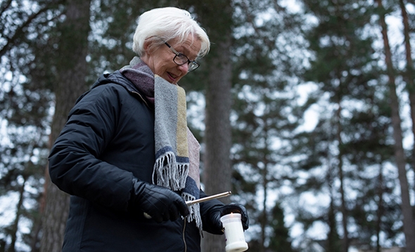 Dame tenner et lys ved en grav