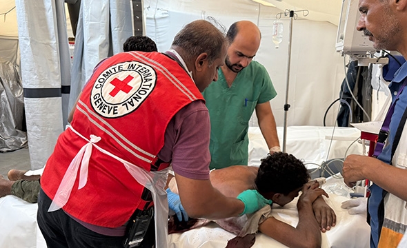 En pasient mottar helsehjelp fra Røde Kors-delegater ved feltsykehuset i Rafah.