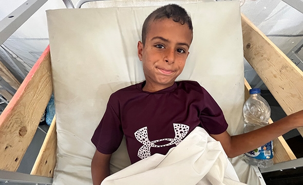 En gutt på 11 år ligger skadet i en sykehusseng.