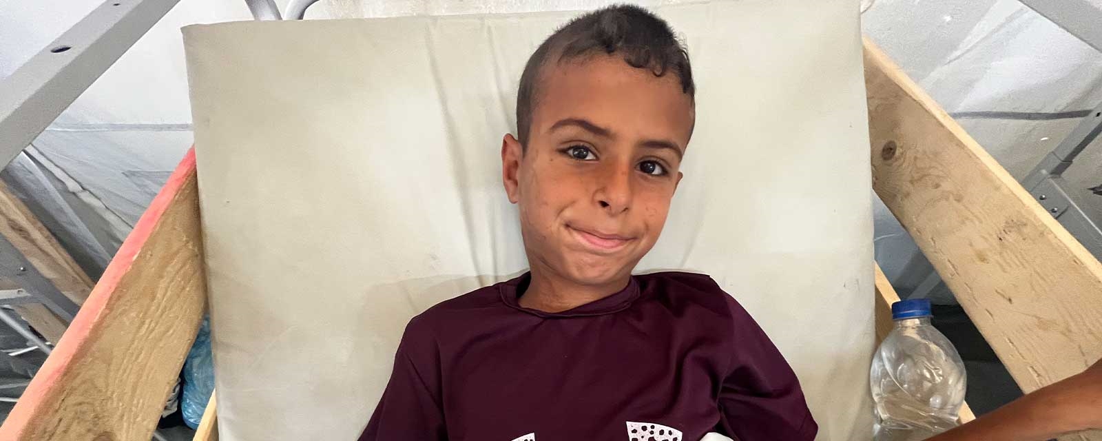 En gutt på 11 år ligger i en sykehusseng.