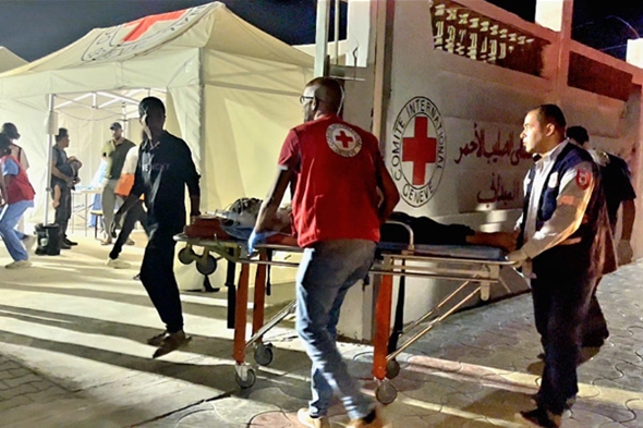 En person blir båret inn på båre til feltsykehus