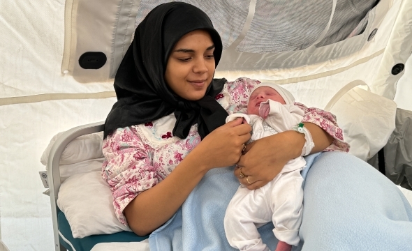 Mor holder sin nyfødte baby i armene